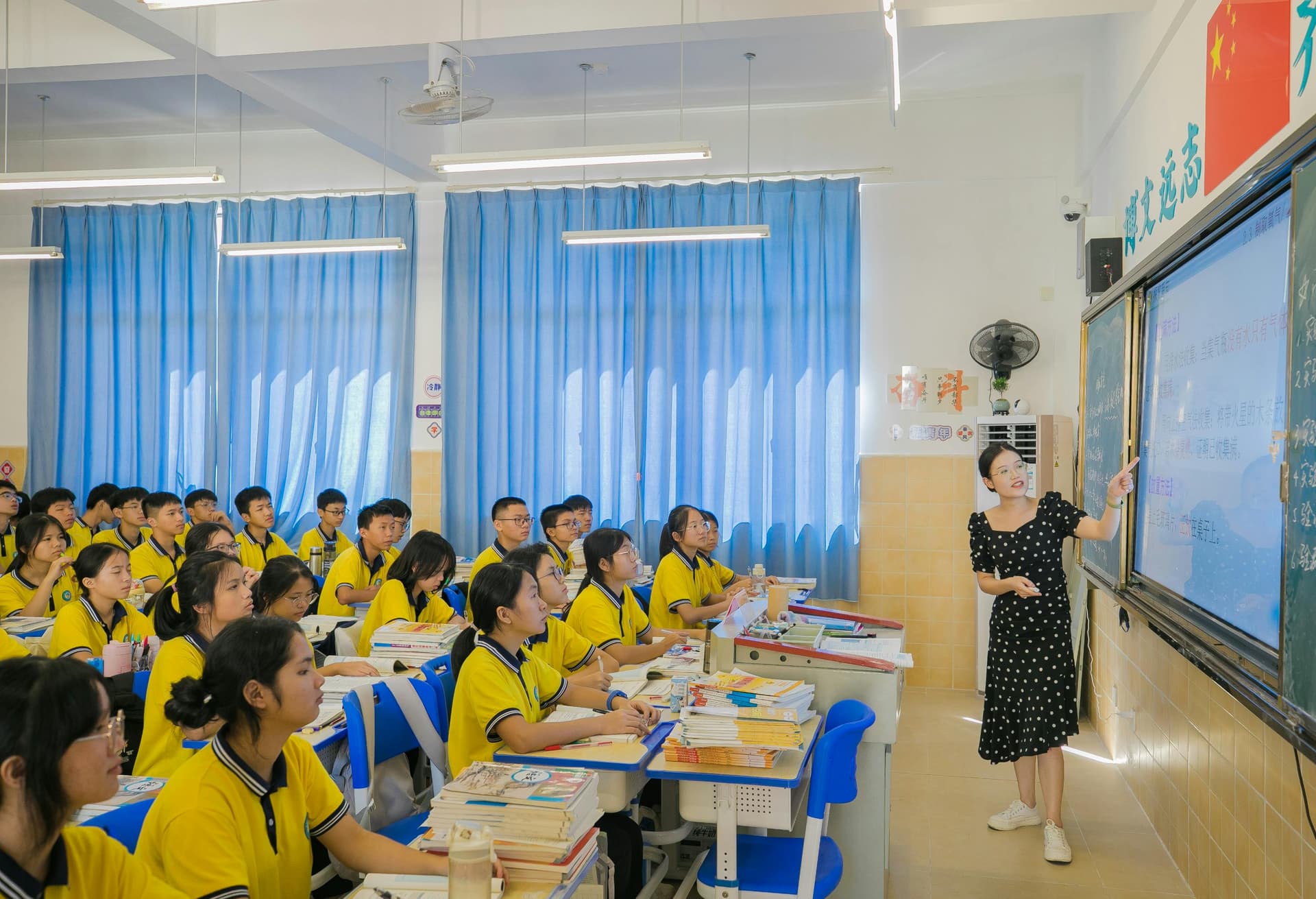International teacher engaging with diverse students in a modern Chinese classroom setting